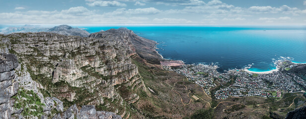 Table mountain from the top, looking out towards the Southern coastline with white fluffy clouds - Great outdoors adventure and travel holiday destination, Cape Town, South Africa