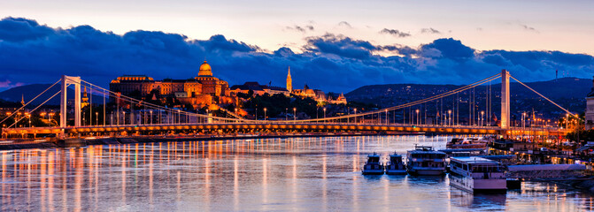 Naklejka na ściany i meble Budapest at night, Erzsebet bridge on the Danube river, reflection of night lights on the water, panoramic shot