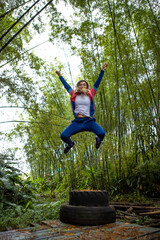 Vertical shot of a Hispanic woman with blonde hair jumping in the air
