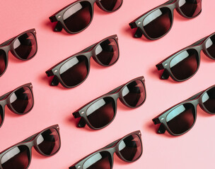 Pattern of sunglasses over a pastel pink background with copy space minimal concept