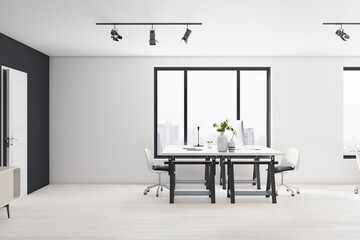 Sunny stylish spacious white shades coworking office with city view from window, black and white table on light wooden floor