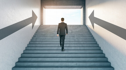 Road to success with climbing stairs businessman in abstract building with arrows indicating the direction to sunny light.