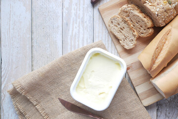 butter in container and whole meal bred on table 