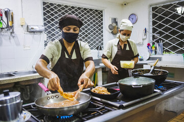 Closeup shot of two Hispanic women cooking dishes in the kitchen