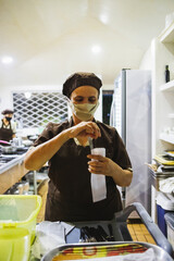 Vertical shot of a Hispanic woman arranging the cutlery
