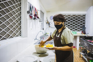 Closeup shot of a Hispanic woman making a salad with veggies