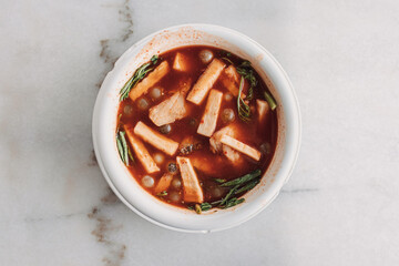 Thai Ryukyu Roe Sour Soup served in white bowl on white table.