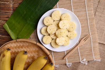 Sliced banana fruit on white dish with fork ready to eating, Tropical fruit
