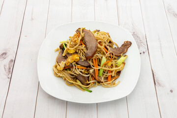 Plate of Asian restaurant noodles sauteed with duck meat, bean sprouts, vegetables