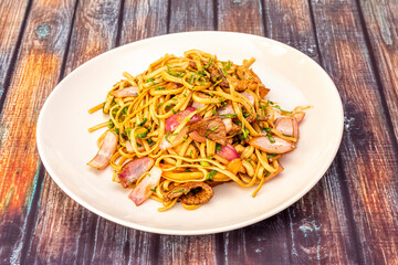 Tallarines saltados or noodles Peruvian style with pieces of onion, meat