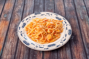 Plate of udon noodles sauteed with shrimp, onion and vegetables
