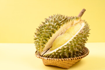 Ripe Thai durian fruit (Monthong) in a basket on yellow background, Tropical fruit