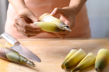 Woman hand peeling bamboo shoot prepare for cooking, Edible vegetable in Asian cuisine