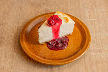 Delicious portion of homemade cheesecake with jam and syrupy ginda