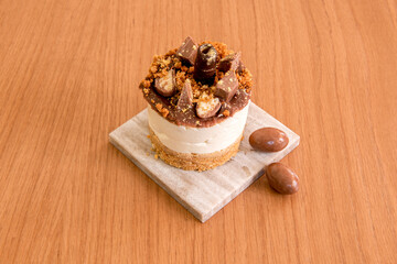 Mini chocolate cheesecake with sprinkles of different kinds of chocolate on a gray marble