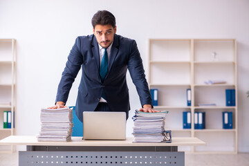 Young businessman employee and too much work in the office