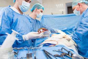 Breast augmentation under the guidance surgeons team in surgical operating room.