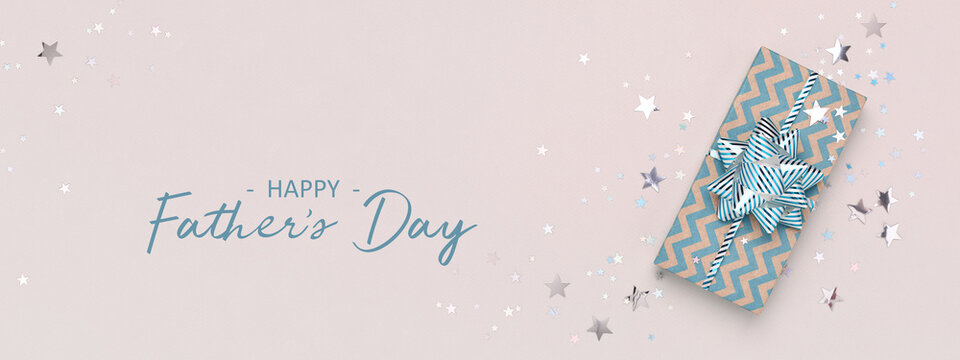 Happy Father's Day banner, blue gift and confetti on beige background.