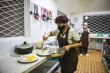 Shot of a Hispanic woman cooking French fries with rice