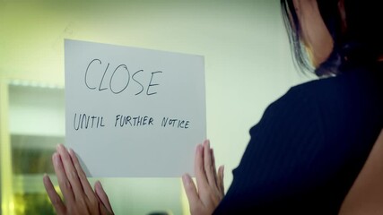 The owner of a small business has to shut her doors and lock up due to recession, pandemic and social distancing - Powered by Adobe