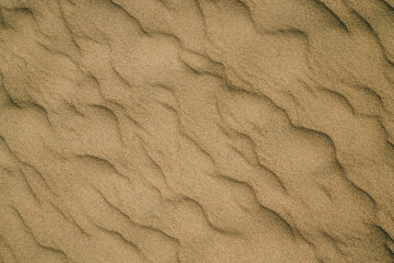 Sand on the beach abstract background, rippled pattern, view from above
