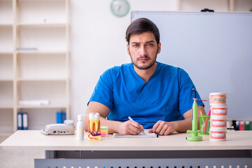 Young male dentist lecturer in front of whiteboard