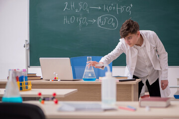 Schoolboy studying chemistry in the classroom