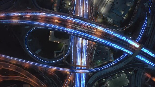 Glowing light trail lines, on city intersection with traffic - 3d render animation - top down aerial