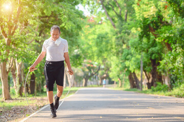 Asian elderly man or senior male Active and healthy Rope skipping exercise In the natural environment in the park - obrazy, fototapety, plakaty