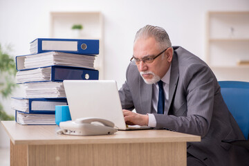 Old male employee unhappy with excessive work in the office