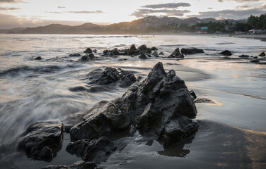 Mexican Beach at Sunrise in Sayulita long exposure image of rocky Pacific beach and sleepy surf village on the mountainside.
