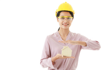 Portrait closeup isolated cutout shot of young smart Asian female construction engineer wears yellow safety hat and goggles stand smile look at camera holding design wooden concept home model in hand