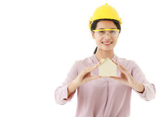 Portrait closeup isolated cutout shot of young smart Asian female construction engineer wears yellow safety hat and goggles stand smile look at camera holding design wooden concept home model in hand