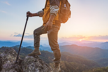 Hiker with backpack standing on top mountain sunset background. Hiker man hiking living healthy active lifestyle.