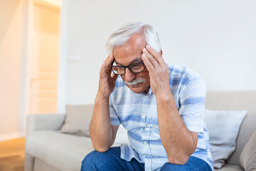 Attack of the monster migraine. Unhappy Retired Senior man holding his head with pain expression ....