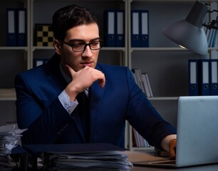 Businessman working late at night in office for overtime bonus