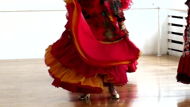 Gypsy dance in slow motion. Wave your dress. Dancing feet. Big skirt of the dress. Musical abstract background. Dancing girl. Ethnic female dance. Gypsy culture pattern.