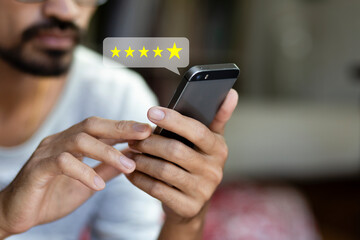 Customer pressing on smartphone with five star icon for feedback review satisfaction service	
