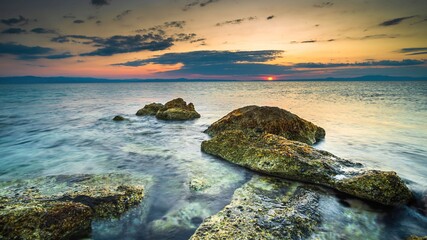 Widok o wschodzie słońca na skały w morzu adriatyckim