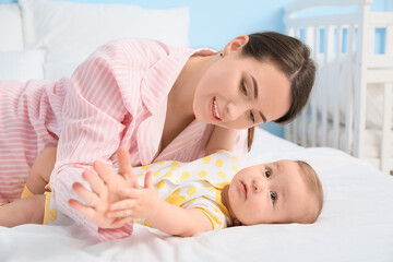 Mother with cute baby lying on bed, closeup