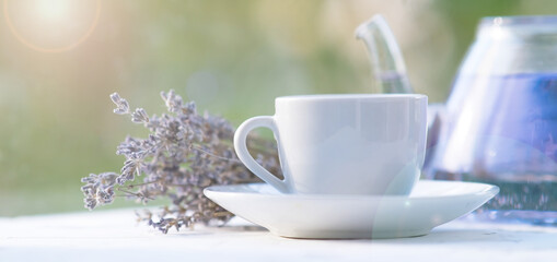bouquet of dried lavender, lavender tea in a teapot and a cup. on a natural background. tea party