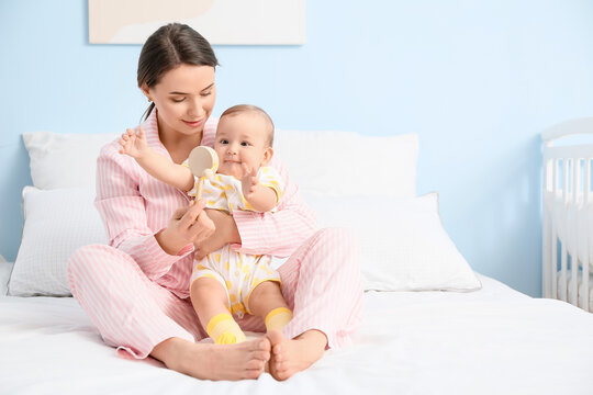 Mother playing with cute baby at home