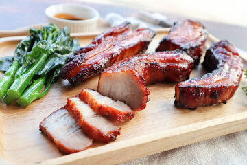 Char Siu - Honey barbecue roast pork on wood tray of wood table - Chinese style grilled pork at close up view