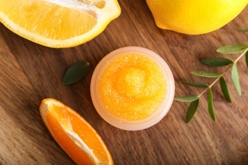 Jar with citrus body scrub on wooden background