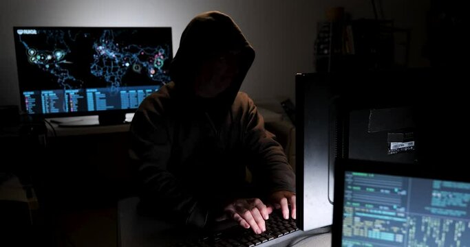 Computer hacker types code attempting to hack a computer server