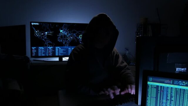 Computer hacker types code attempting to hack a computer server