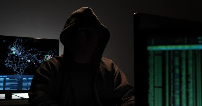 Computer hacker types code attempting to hack a computer server