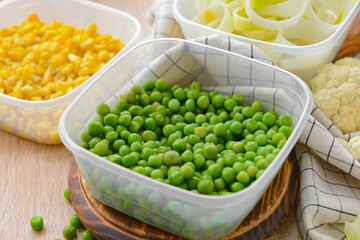 Plastic containers with vegetables on wooden background, closeup