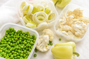 Plastic containers with vegetables on light background, closeup