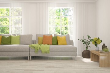 Fototapeta premium Minimalist living room in white color with sofa and summer landscape in window. Scandinavian interior design. 3D illustration